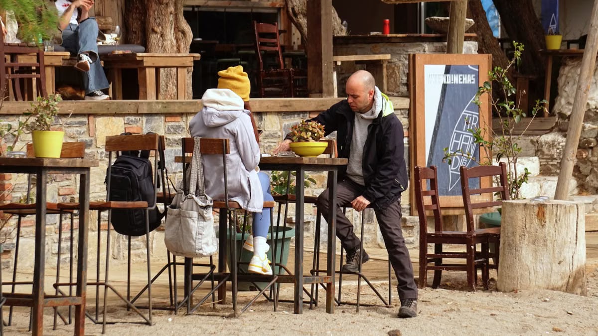 Casual outdoor café scene with people enjoying a relaxed day under trees.